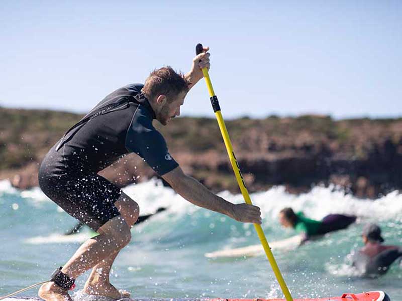 Stand Up paddling in der Welle auf St.Pietro in Italien SUP und Yoga Reise nach Italien mit dem StandUPClub Berlin